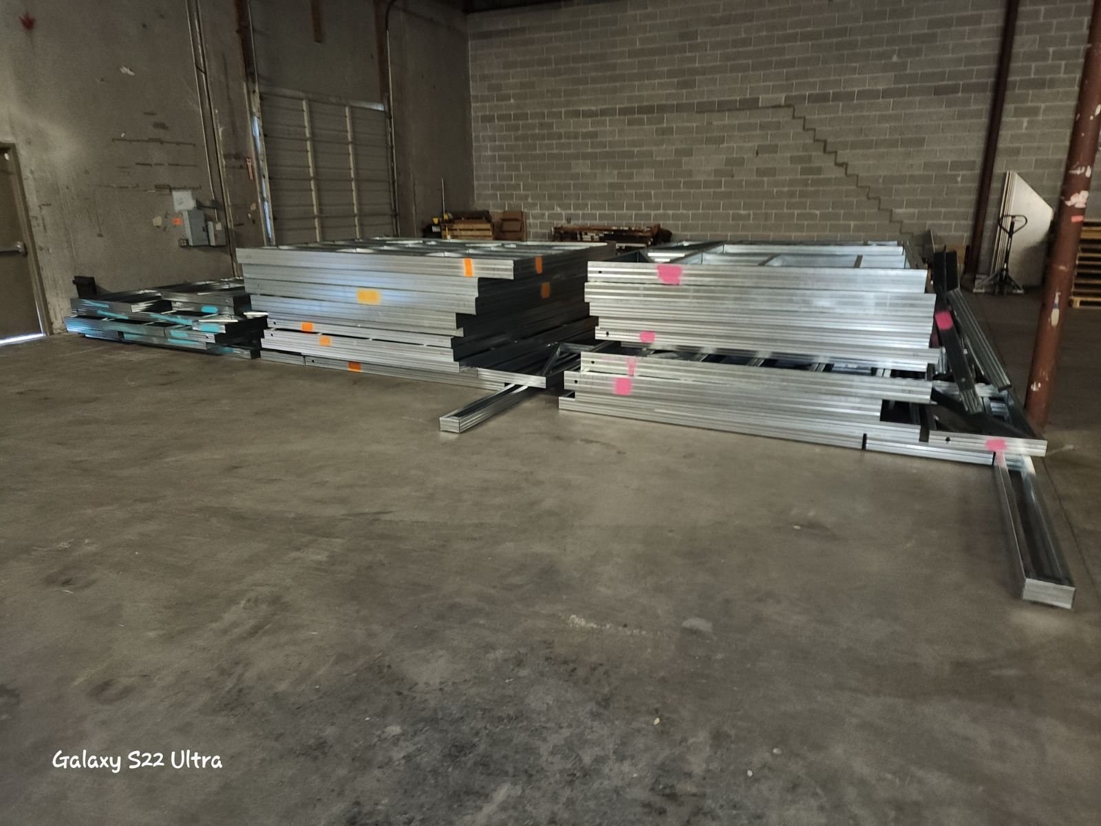 Bundled structural steel framing members staged in warehouse